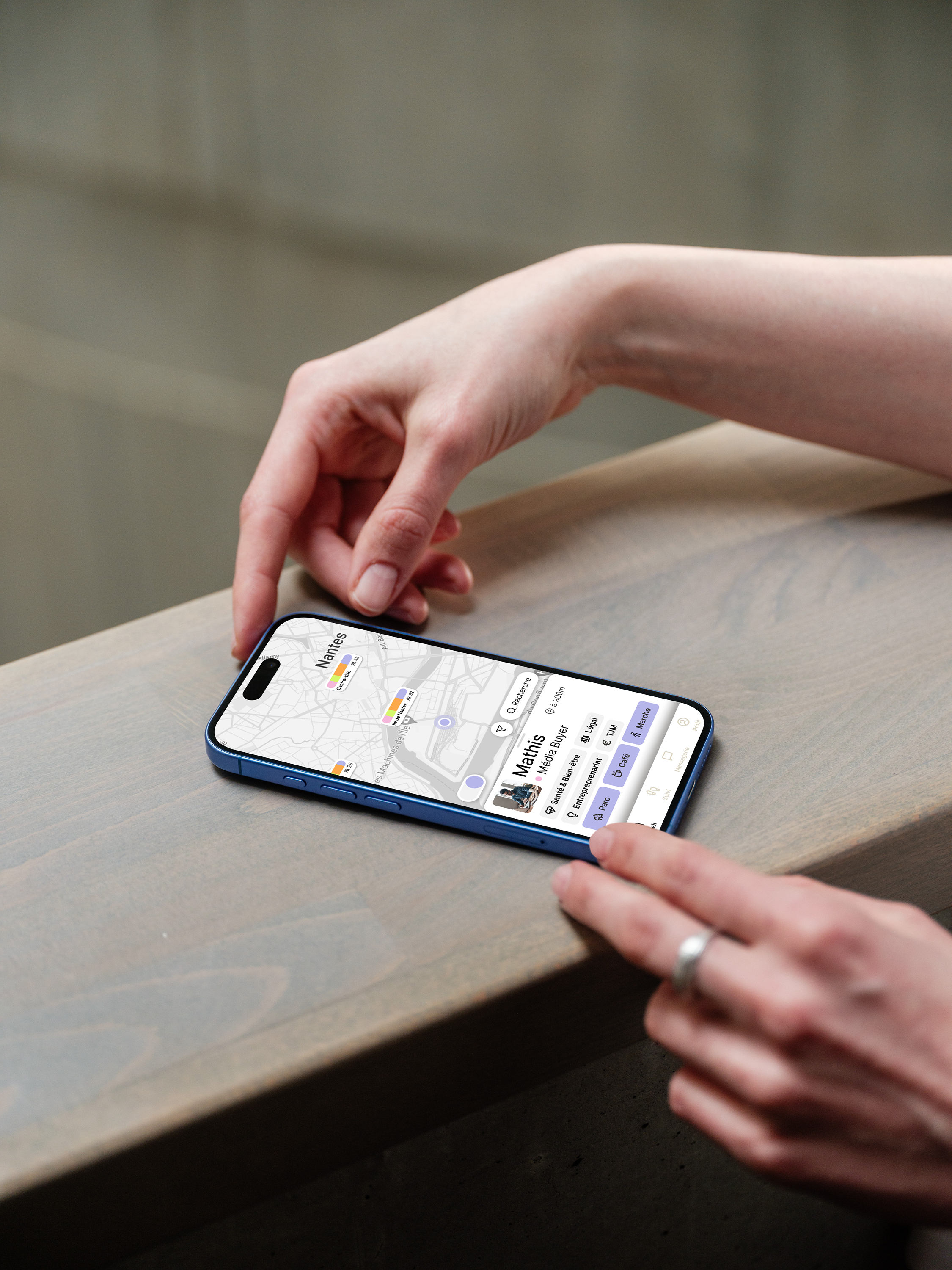 mockuuups-iphone-16-mockup-on-a-wooden-surface-with-a-hand-interacting 1